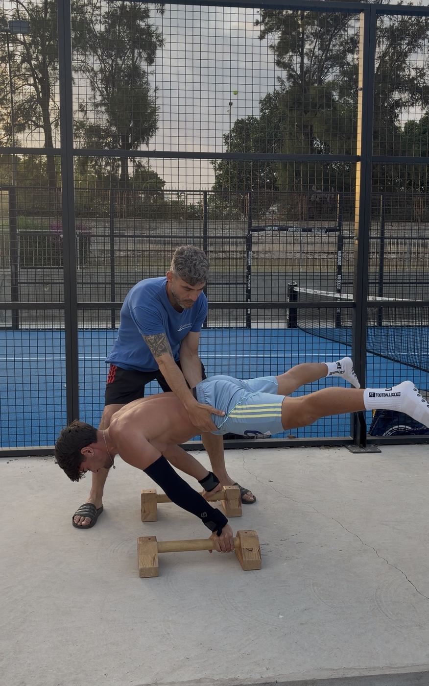 Vincenzo segue un allievo durante un esercizio di planche alle parallele