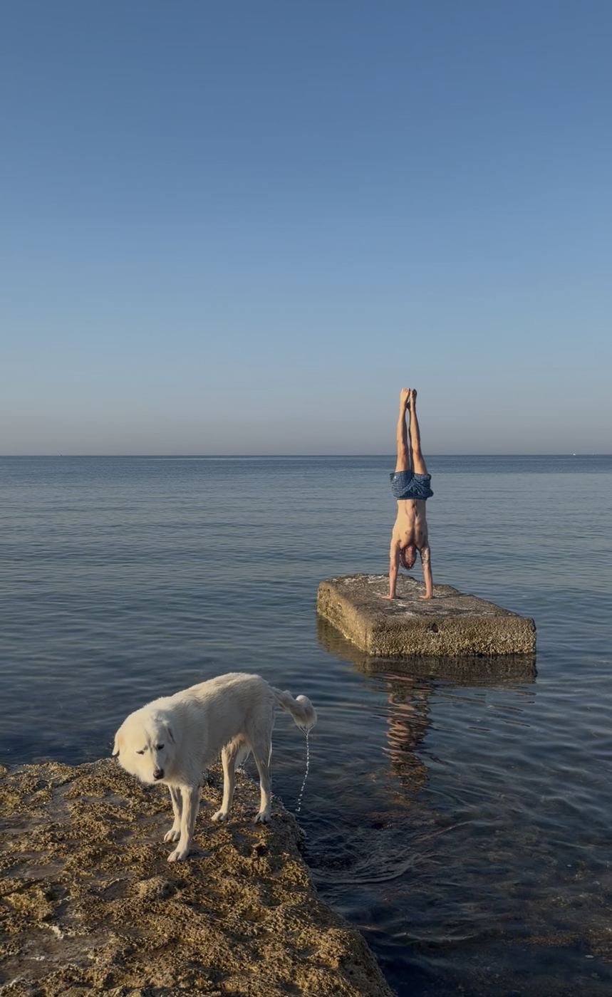 Vincenzo Cimino in verticale su uno scoglio nel mare di Siracusa